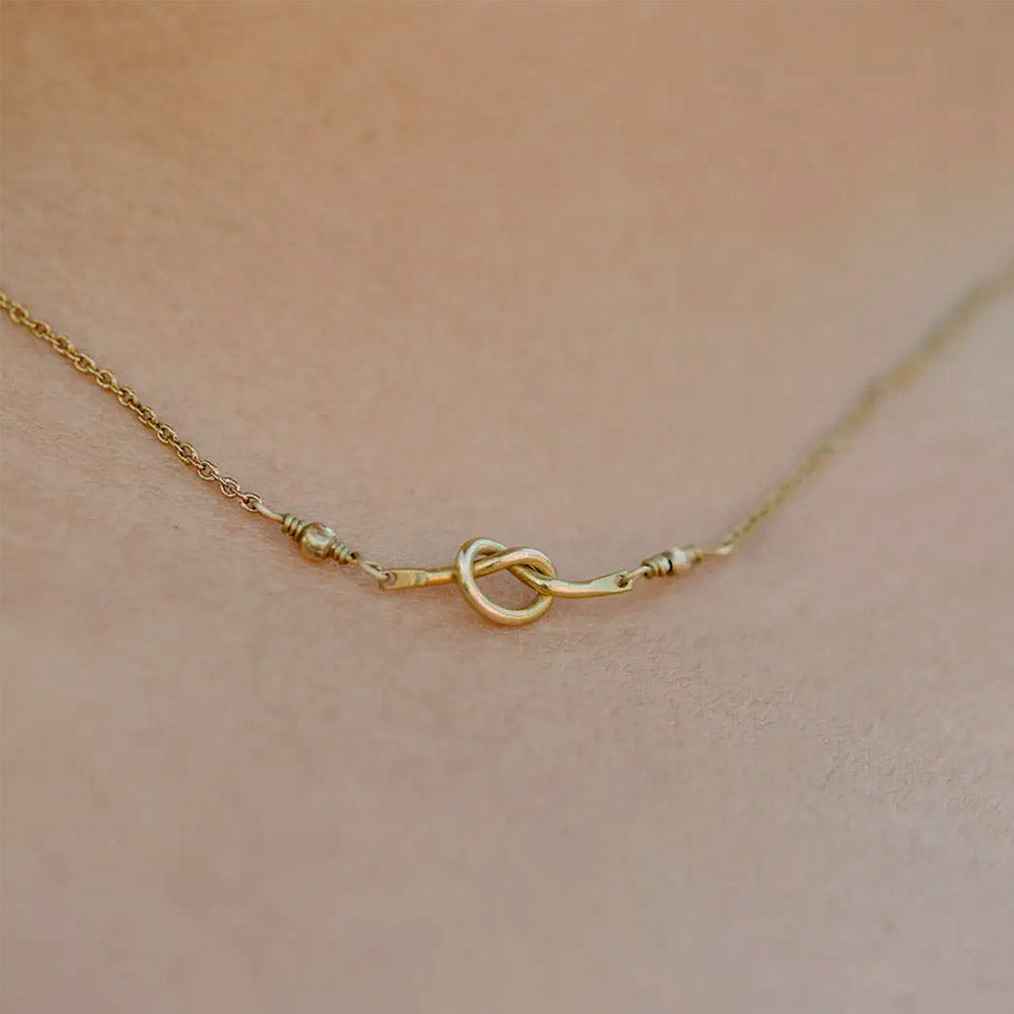 Fair trade brass knot necklace handmade by survivors of human trafficking.