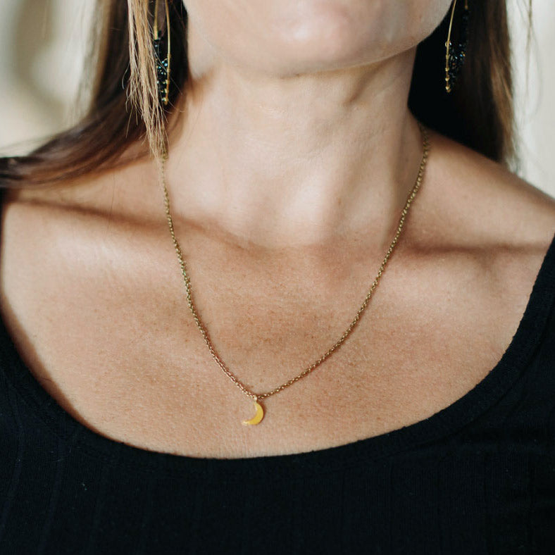 Fair trade brass moon necklace handmade by survivors of human trafficking.